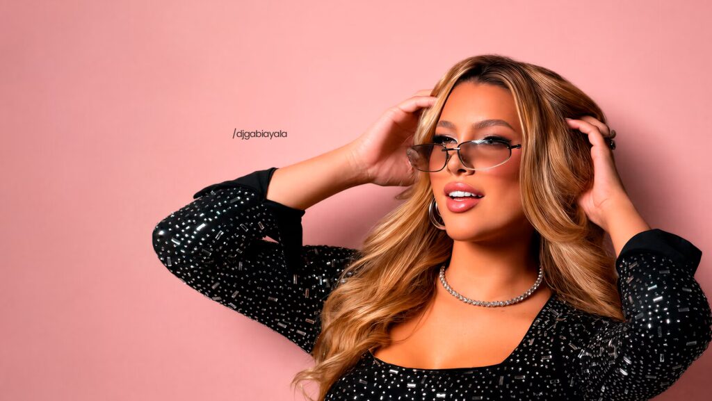 DJ Gabriela Ayala está com as duas mãos na cabeça. Na altura dos ouvidos.