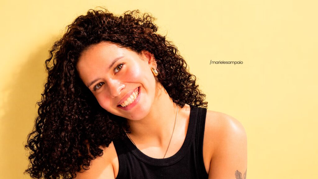 Mariele Sampaio sorrindo e com a cabeça inclinada para a esquerda.