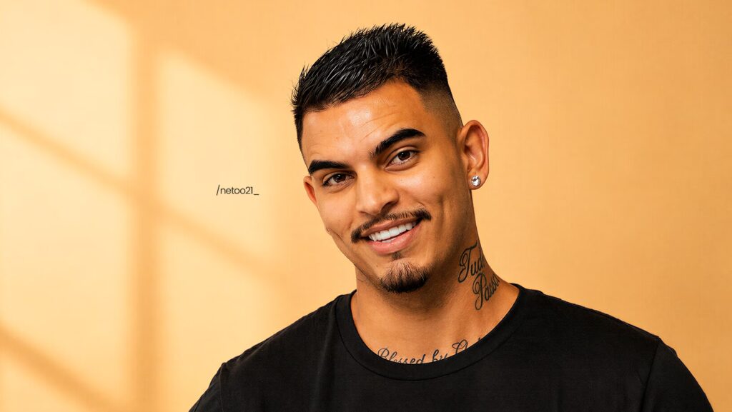 Neto está usando uma camiseta preta.