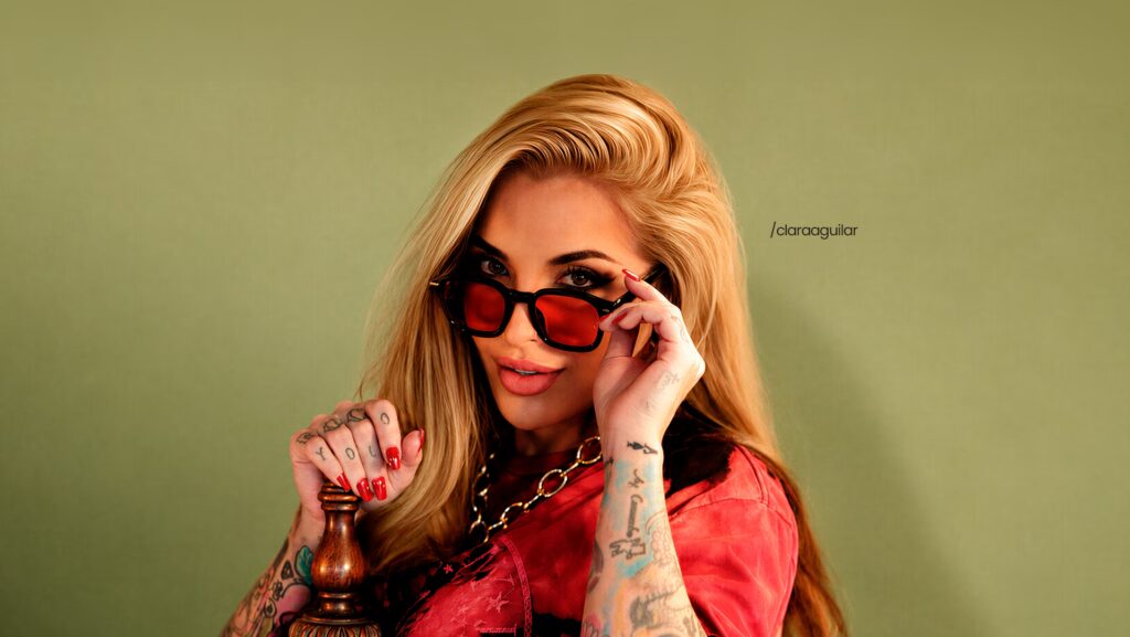 Clara Aguilar utilizando um óculos vermelho.