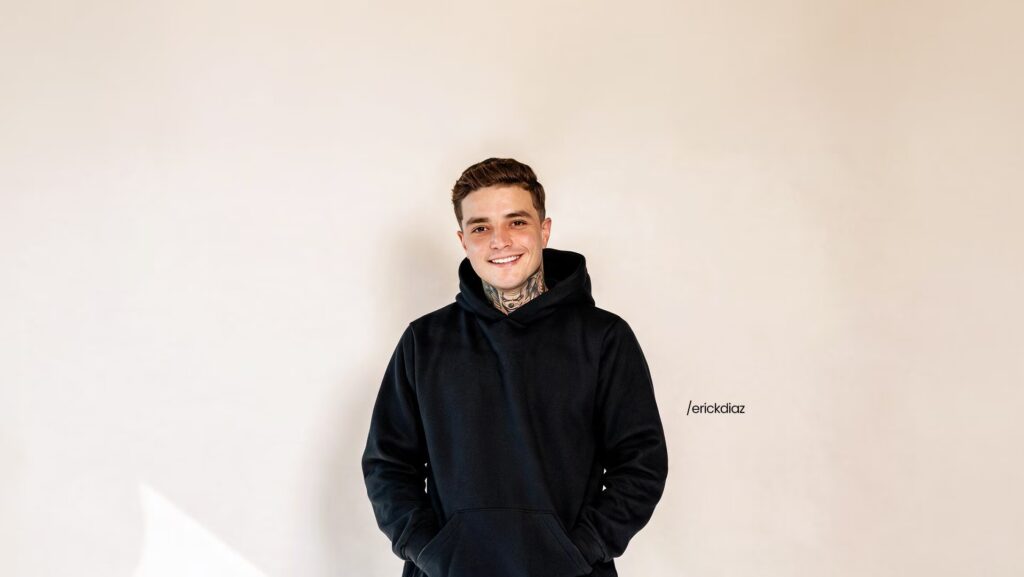 Erick Diaz utilizando um moleton preto. Ele está sorrindo