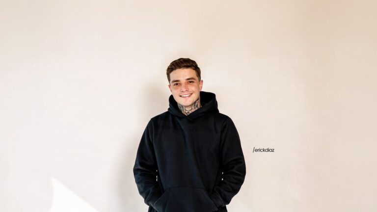 Erick Diaz utilizando um moleton preto. Ele está sorrindo