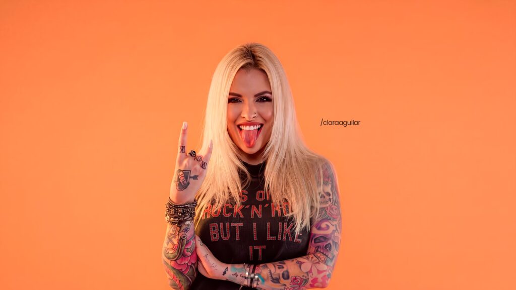 Clara Aguilar olhando pra frente e com a lingua pra fora.