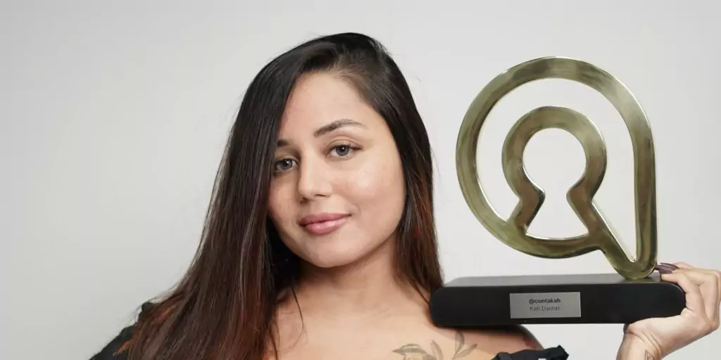 KArine Dantas segurando o troféu de 1 milhão de faturamento